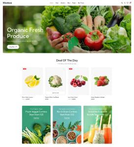 Startseite eines Bio-Lebensmittelshops mit großem Bannerfoto frischer Gemüse und Früchte (Paprika, Tomaten, Brokkoli, Salat), darunter eine „Deal Of The Day“-Produktreihe mit Karten für Zitrone, Blumenkohl, Kirschen und Erdbeeren sowie drei farbigen Werbebannern für Gemüsekisten, Nussmischungen und Säfte/Smoothies.