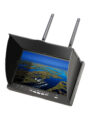 Tragbarer Monitor mit seitlicher Sonnenblende und zwei Antennen, dessen Bildschirm eine Luftaufnahme von Insel‑ und Wasserlandschaft mit einem Boot zeigt.