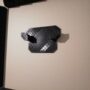 Schwarzes 3D-gedrucktes Wandhalterungsstück mit zwei abgewinkelten Haken und sichtbarem Schichtraster, montiert an einer hellen Wand.