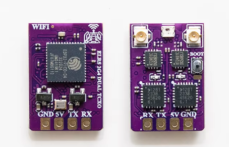 Zwei kleine violette Leiterplatten nebeneinander auf weißem Hintergrund; links ein Modul mit großem Wi‑Fi‑Chip, der Aufdruck 'WIFI' und Lötpads 'GND 5V TX RX', rechts ein Modul mit zwei U.FL‑Antennenanschlüssen, mehreren ICs, einem kleinen Taster 'BOOT' und Lötpads 'RX TX 5V GND'.
