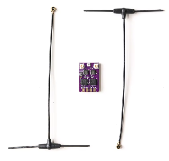 Zwei schwarze, T-förmige Antennenkabel mit goldenen Steckverbindern liegen links und rechts eines kleinen violetten Leiterplattenmoduls mit vier ICs und goldenen Lötpads auf weißem Hintergrund.