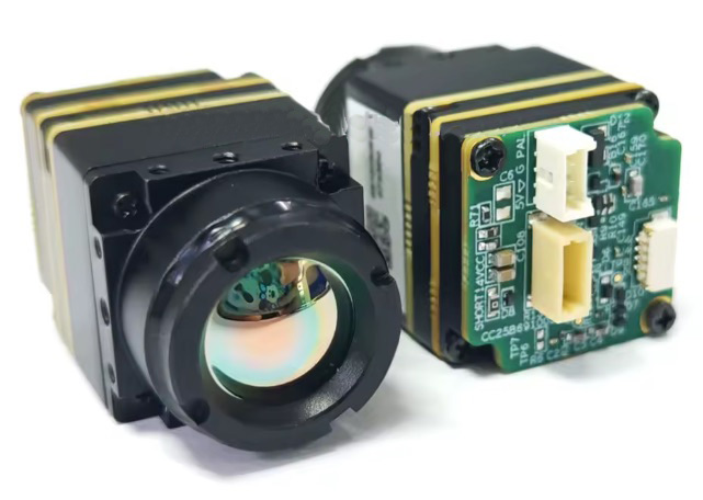 cvbs-fpv-waermebildkamera-12um-mikrokameramodul Zwei kompakte Wärmebildkamera‑Module für FPV‑Drohnen: eines mit konvexer Linse und grünlich schimmernder Vergütung, das andere mit freiliegender Platine und weißen Steckern; schwarze Gehäuse mit goldenen Abstandshaltern vor weißem Hintergrund.