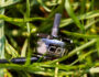 FPV-Drohnenmotor mit glänzendem Metallgehäuse, sichtbarer Serienbeschriftung und hervorstehender Antriebswelle, liegend zwischen dichtem grünem Gras.