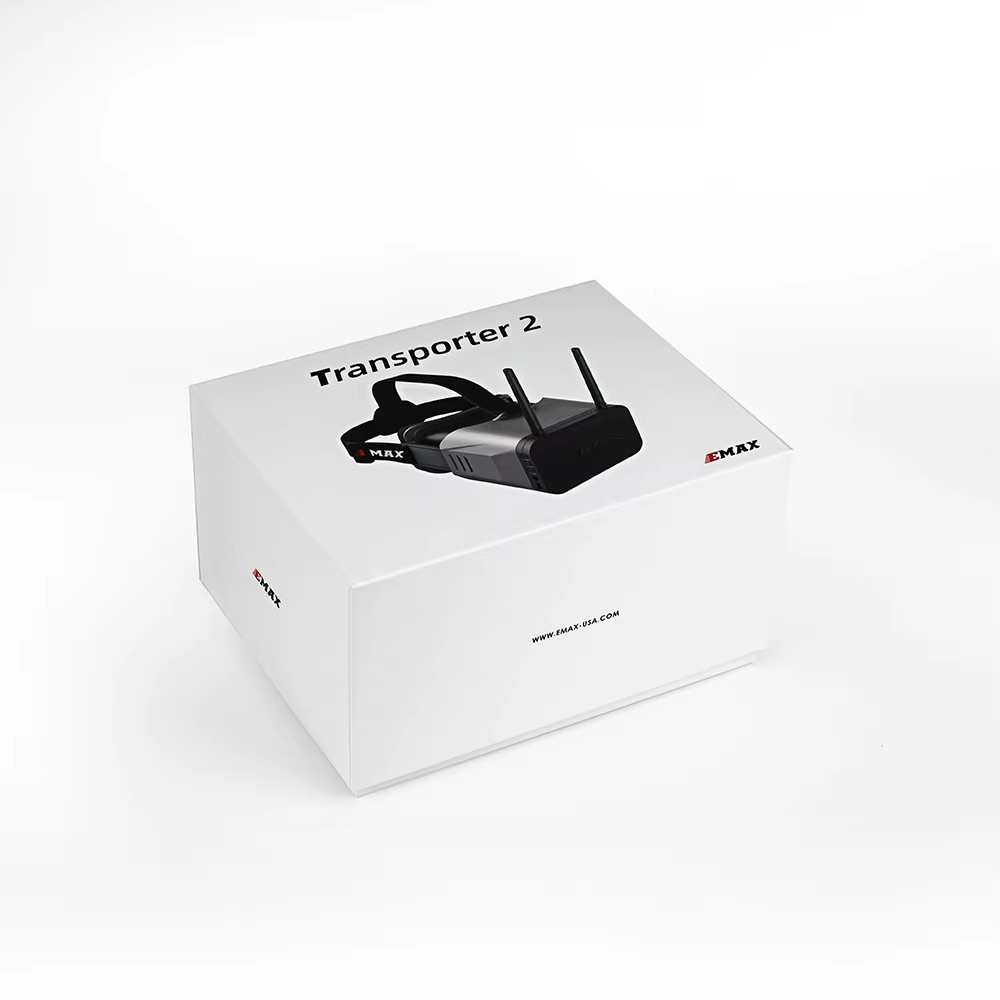 emax-fpv-racing-brille-43-zoll-800x480-display Weiße Verpackung mit der Aufschrift „Transporter 2“ und Abbildung einer schwarzen FPV-Brille mit Stirnband und zwei Antennen, Markenlogo EMAX sichtbar