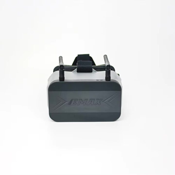 emax-transporter-2-43-zoll-fpv-brille-seitlich FPV-Brille mit dunkler Frontplatte mit EMAX-Logo, zwei aufgesetzten Antennen und schwarzem Kopfband vor hellem Hintergrund.