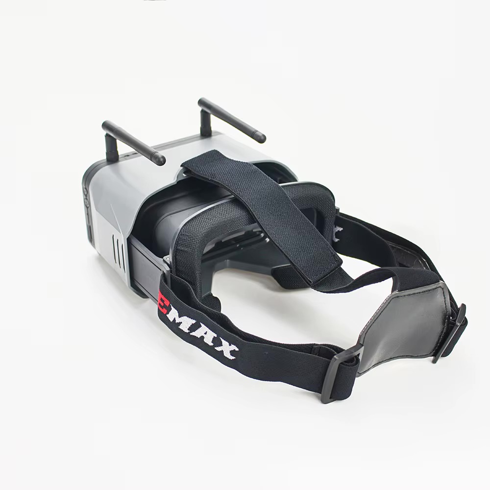 emax-transporter-2-goggle-fuer-racing-drohnen FPV-Brille in Grau-Schwarz mit zwei Antennen, weicher Gesichtspolsterung und verstellbarem Kopfband mit EMAX-Logo auf weißem Hintergrund.
