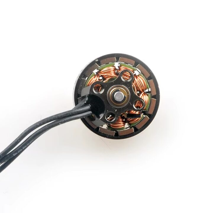 Nahaufnahme eines runden FPV‑Drohnen‑Brushless‑Motors, frontal gezeigt mit freiliegenden kupferfarbenen Wicklungen im Stator, zentraler Motorwelle und drei schwarzen Anschlusskabeln.