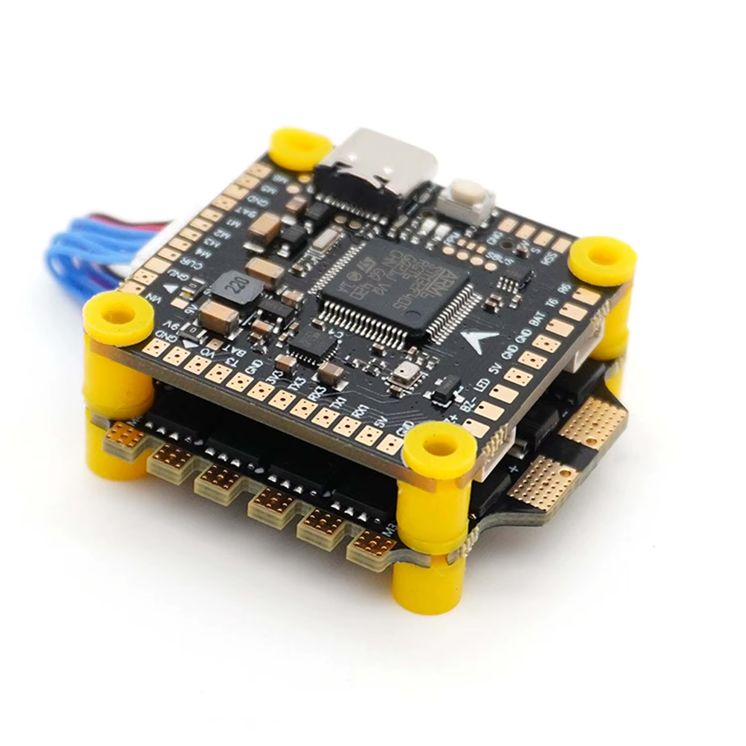 Kompakter Flight-Controller- und ESC-Stack für FPV-Drohnen aufeinandergestapelt, schwarze Platinen mit gelben Nylon-Abstandhaltern, USB-C-Anschluss, vielen Lötpads und sichtbaren SMD-Bauteilen.