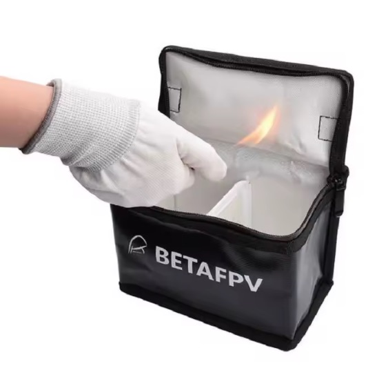 Screenshot Offene schwarze Tasche mit Markenaufdruck BETAFPV und weißer Innenauskleidung, in der eine kleine Flamme lodert, während eine handschuhtragende Hand in die Tasche greift.