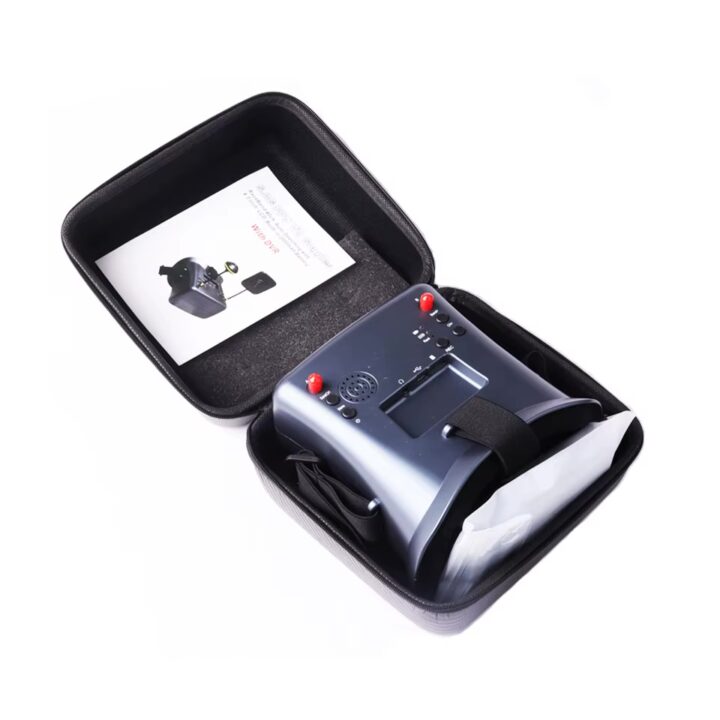 fpv-brille-58g-mit-ladekabel-und-zubehoer FPV‑Drohnen‑Brille in einer offenen schwarzen Tragetasche, dunkelgraue Videobrille mit Kopfband, Bedienelementen und eingebautem Lautsprecher sowie einer Bedienungsanleitung im Deckel.