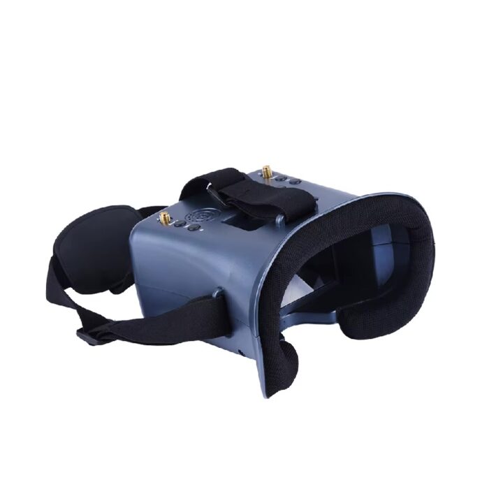 fpv-brille-fuer-fpv-drohne-und-fpv-racing Graue FPV-Drohnenbrille mit schwarzer Schaumstoff-Augenauflage, verstellbaren Kopfriemen, Bedienknöpfen und zwei goldenen Antennenanschlüssen auf der Oberseite.
