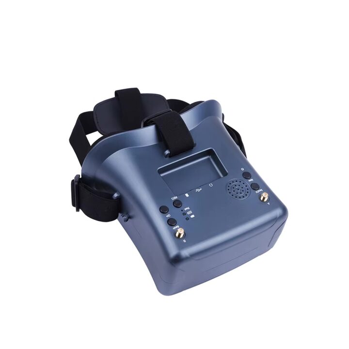 fpv-brille-mit-integriertem-akku-und-hell-display Dunkelblaue FPV-Drohnenbrille mit verstellbaren Kopfriemen, kleinem Displayfach, Bedientasten, Lautsprechergitter und zwei goldenen Antennenanschlüssen.