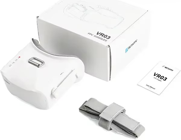 Weiße FPV‑Goggles für Drohnen (Modell VR03) liegend neben der Verpackung, einer Bedienungsanleitung und einem aufgerollten grauen Kopfband auf weißem Hintergrund.