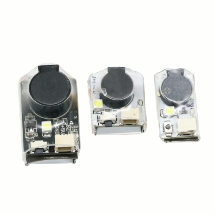 fpv-buzzer-finder-mit-integriertem-akku-und-led Drei kleine transparente elektronische Module nebeneinander (links groß, Mitte mittel, rechts klein), jeweils mit rundem schwarzem Piezo-Lautsprecher, einer weißen SMD-LED und einem USB-Anschluss auf weißem Hintergrund.