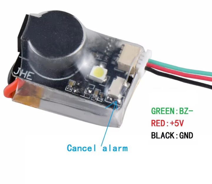 fpv-buzzer-jhe20b-ultrakompakt-und-leistungsstark Nahaufnahme eines kleinen elektronischen Alarmmoduls unter transparenter Schrumpffolie mit schwarzer runder Summerkappe, einer gelben LED, einem weißen Steckverbinder und drei abgehenden Drähten (grün, rot, schwarz) neben den Beschriftungen GREEN: BZ–, RED: +5V, BLACK: GND sowie einem Pfeil mit der Beschriftung „Cancel alarm“.