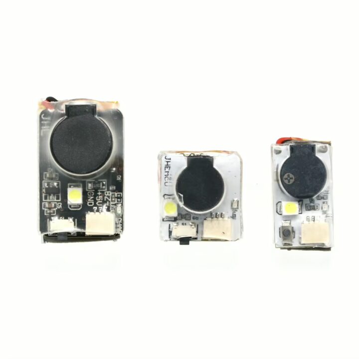fpv-drohne-buzzer-verlustschutz-mit-alarm Drei kleine rechteckige Elektronikmodule auf weißem Hintergrund, jeweils mit rundem schwarzem Lautsprechergehäuse, einer LED und Anschlusssteckern; links das größte Modul, Mitte und rechts zwei kleinere Varianten.