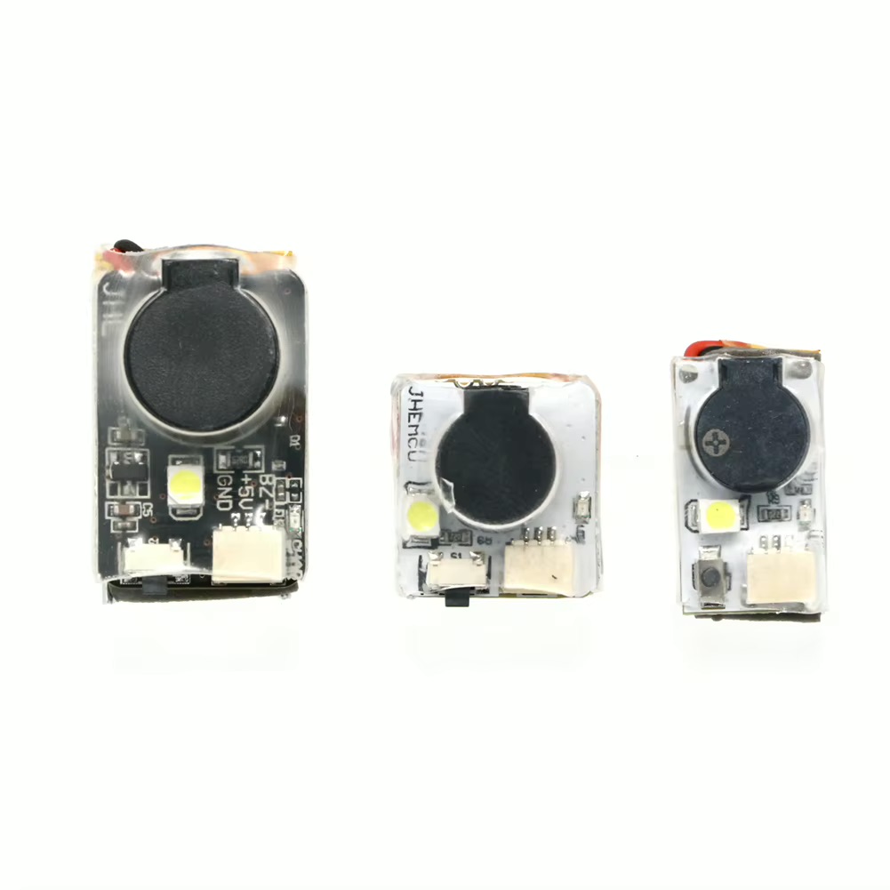 Drei kleine rechteckige Elektronikmodule auf weißem Hintergrund, jeweils mit rundem schwarzem Lautsprechergehäuse, einer LED und Anschlusssteckern; links das größte Modul, Mitte und rechts zwei kleinere Varianten.