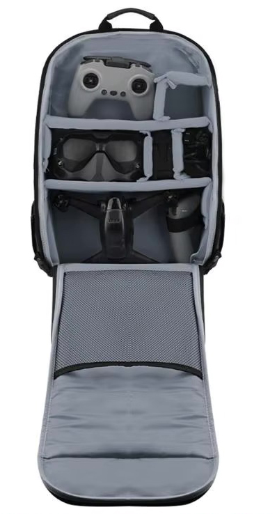 Offener, gepolsterter Drohnenrucksack mit Inneneinteilung: oben eine Fernsteuerung, mittig eine FPV-Brille, unten der zusammengeklappte Drohnenkörper und in der aufgeklappten Klappe ein Netzfach.