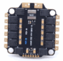 Schwarze quadratische 4‑in‑1 ESC-Leiterplatte für Drohnen mit abgerundeten Ecken und vier Montagebohrungen, goldenen Lötpads an den Rändern, mehreren MOSFETs entlang der Seiten, zentralem Spulenbauteil mit Aufdruck "0m50" und Beschriftung "B-CUBE 4IN1 ESC MK4" sowie Plus-/Minus‑Markierung oben.