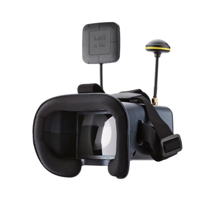 fpv-goggles-fuer-drohnen-mit-dvr-und-empfaenger FPV‑Brille mit dunkelgrauem Gehäuse und schwarzer Gesichtspolsterung, sichtbaren Linsen, verstellbarem Kopfband und zwei externen Antennen (flaches Patch mit Aufdruck 5.8G 14DBI und runde Antenne).