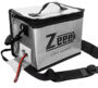 Silberne rechteckige LiPo-Sicherheitsbox mit Reißverschluss, Tragegriff und abnehmbarem Schultergurt, Vorderseite mit Schriftzug „Zeep LIPO GUARD“ und ein rot-schwarzes Batteriekabel, das durch eine seitliche Öffnung führt.