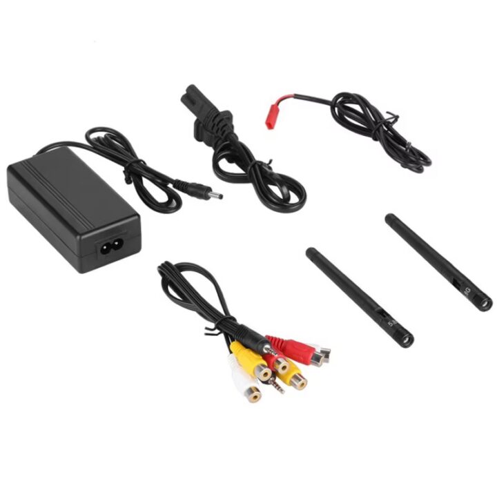 Netzteil mit angeschlossenen Kabeln, zwei schwarze Stabantennen, ein dünnes Kabel mit rotem Stecker und ein Bündel Audio-/Video-Cinchkabel (gelb, weiß, rot) auf weißem Hintergrund.
