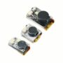 Drei kleine, transparent vergossene Elektronikmodule auf weißem Hintergrund, jeweils mit rundem schwarzen Buzzer/Lautsprecher, einer LED und roten sowie schwarzen Anschlussdrähten.
