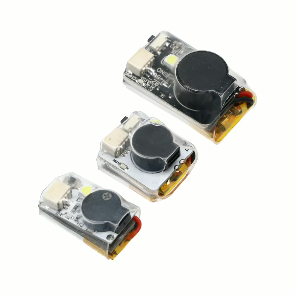Drei kleine, transparent vergossene Elektronikmodule auf weißem Hintergrund, jeweils mit rundem schwarzen Buzzer/Lautsprecher, einer LED und roten sowie schwarzen Anschlussdrähten.
