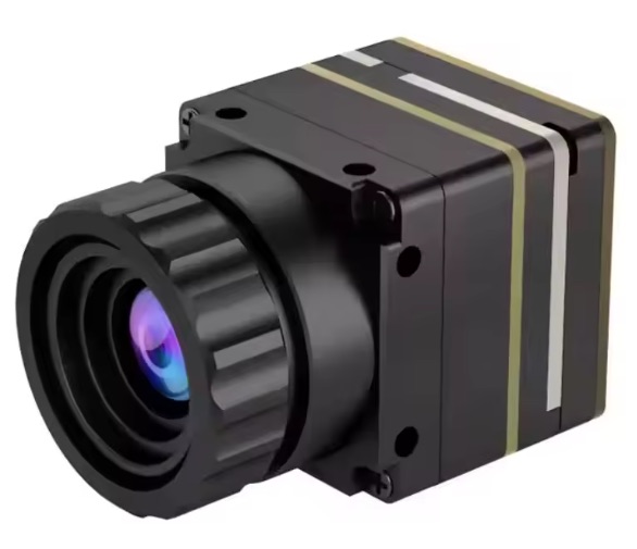 Kompakte Wärmebildkamera für FPV‑Drohnen: schwarzes rechteckiges Metallgehäuse mit vorn sitzendem gerilltem Objektiv und violett‑bläulicher Linse, seitlichen Montagebohrungen und goldenen sowie silbernen Zierstreifen am Gehäuse