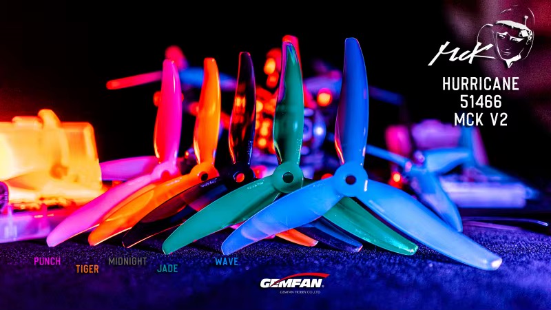 gemfan-51466-v2-propeller-cw-ccw-farben Reihe bunter 5-Zoll-FPV-Dreiblattpropeller in unterschiedlichen Farben (Punch, Tiger, Midnight, Jade, Wave) auf dunklem Untergrund mit neonfarbener Beleuchtung und sichtbaren Markenlogos (Gemfan, Hurricane).