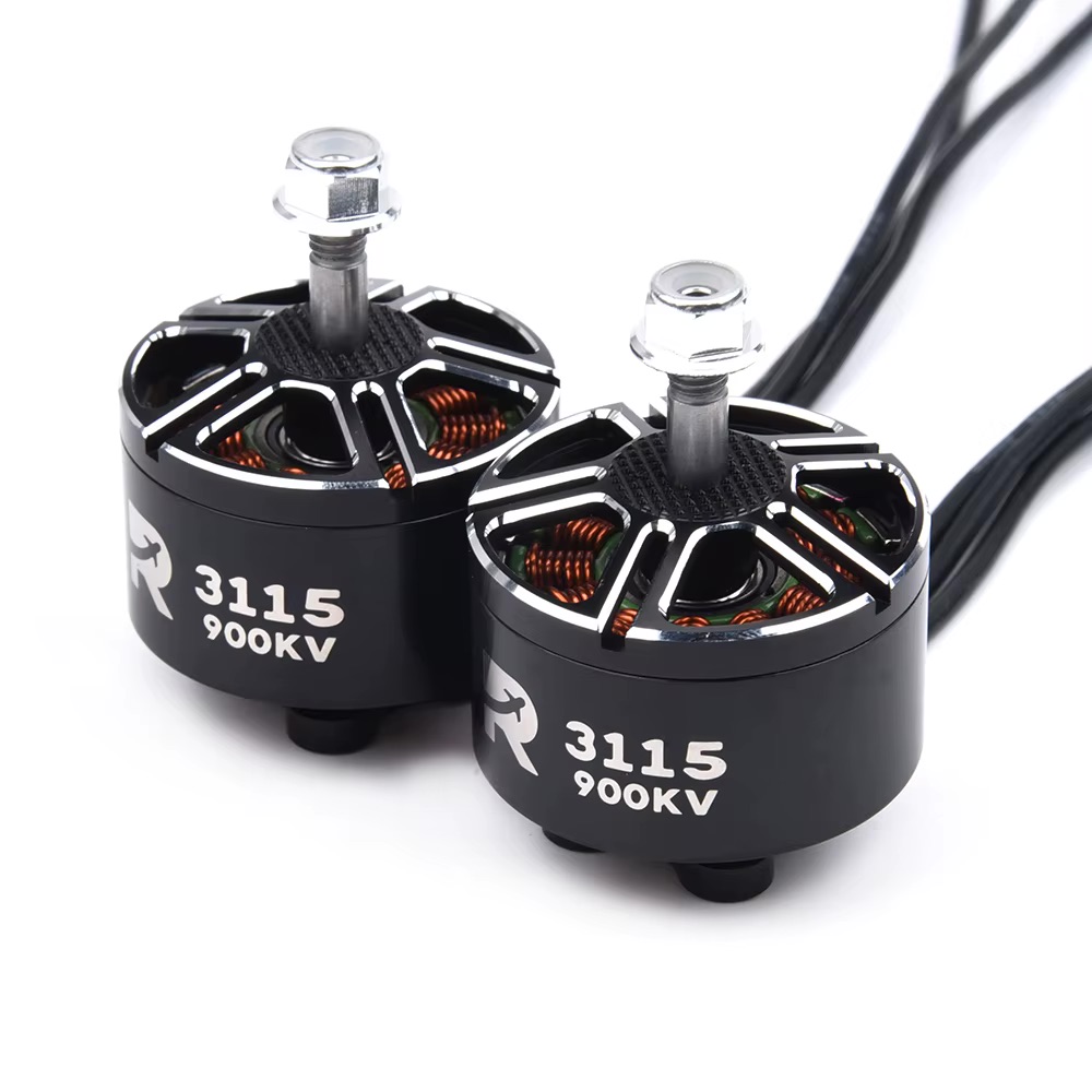 Zwei schwarze FPV-Brushless-Drohnenmotoren mit Aufdruck "3115 900KV", sichtbaren kupferfarbenen Wicklungen, zylindrischen Wellen mit Propellermuttern und drei herausführenden Anschlusskabeln auf weißem Hintergrund.