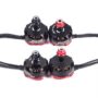 Vier schwarze-rote FPV-Brushless-Motoren (RS2205, 2300KV) mit sichtbaren Kupferspulen und Anschlusskabeln auf weißem Hintergrund.