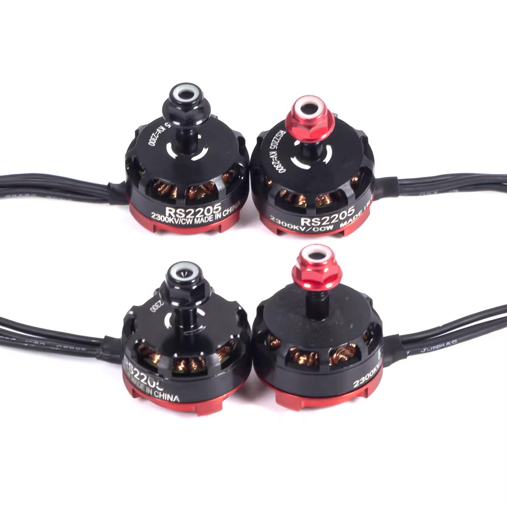 Vier schwarze-rote FPV-Brushless-Motoren (RS2205, 2300KV) mit sichtbaren Kupferspulen und Anschlusskabeln auf weißem Hintergrund.