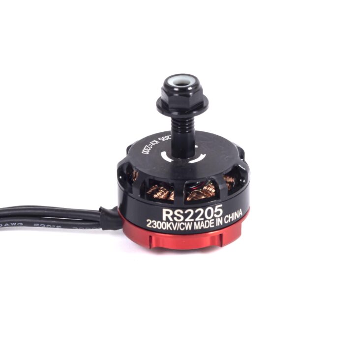 Kompakter FPV-Drohnenmotor Modell RS2205 in Schwarz und Rot mit sichtbaren Kupferwicklungen, drei Anschlusskabeln und einer zentralen Gewindespindel, auf der 2300KV/VCW MADE IN CHINA und Richtungspfeile zu sehen sind.