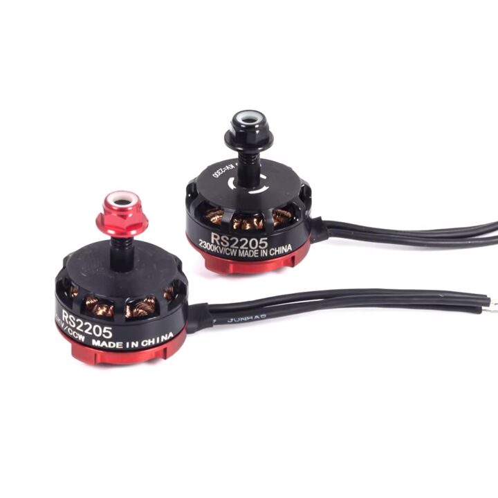 Zwei kompakte FPV-Drohnen-Brushless-Motoren (RS2205) mit rotem Aluminiumfuß, sichtbaren Kupferwicklungen, montierten Propellernuten und schwarzen Anschlusskabeln vor hellem Hintergrund.