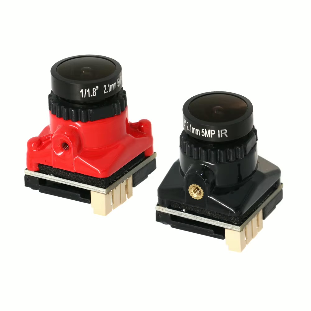 Zwei kleine Kameramodule auf Platinen, eines rot und eines schwarz, mit aufgesetzten Weitwinkelobjektiven (aufgedruckt „2.1mm 5MP IR“) und Anschlussleisten vor weißem Hintergrund.