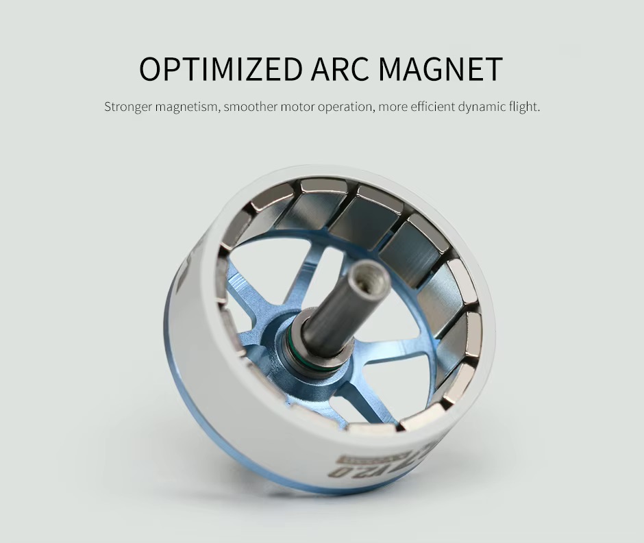 Nahaufnahme eines weißen und blauen bürstenlosen FPV‑Drohnenmotors mit offenem Gehäuse, sichtbaren gebogenen Magnetsegmenten am Innenrand und einer zentralen Metall-​Antriebswelle vor hellem Hintergrund.