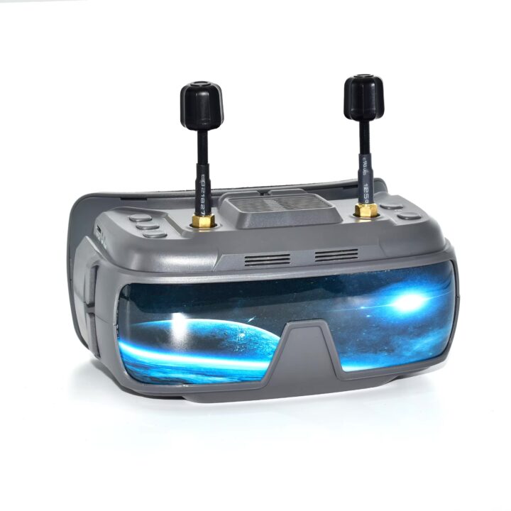 vr200-fpv-brille-hd-display-fuer-racing-drohnen Graue FPV-Drohnen-Brille mit zwei kurzen Antennen auf der Oberseite, Bedienknöpfen und einer spiegelnden blau leuchtenden Visierfläche, die eine Weltraum-/Planeten-Grafik zeigt.
