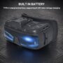 Schwarze FPV‑Drohnenbrille mit integriertem Akku, sichtbaren Bedientasten und Type‑C/HDMI‑Anschlüssen sowie blau leuchtendem, galaktischem Displaymotiv, auf einer strukturierten dunklen Oberfläche präsentiert.